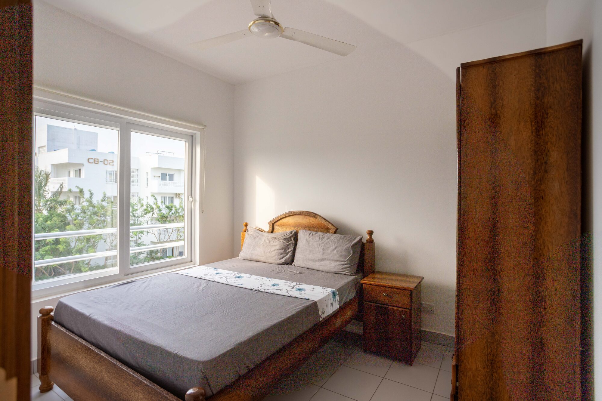 Main bedroom with hardwood bed frame and garden view