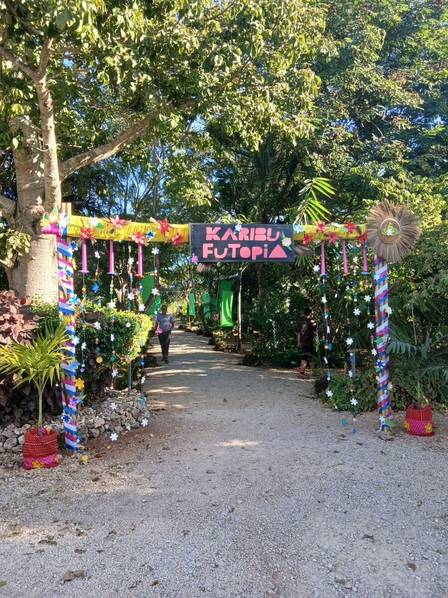 Colourful Karibu Futopia entrance arch decorated with flowers and flags in Fumba Town, Zanzibar